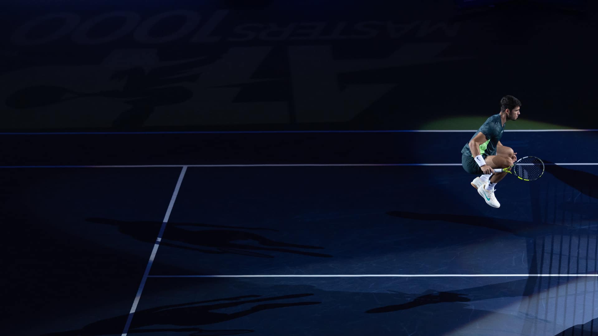 Carlos Alcaraz jumping during a night match at the Shanghai Masters